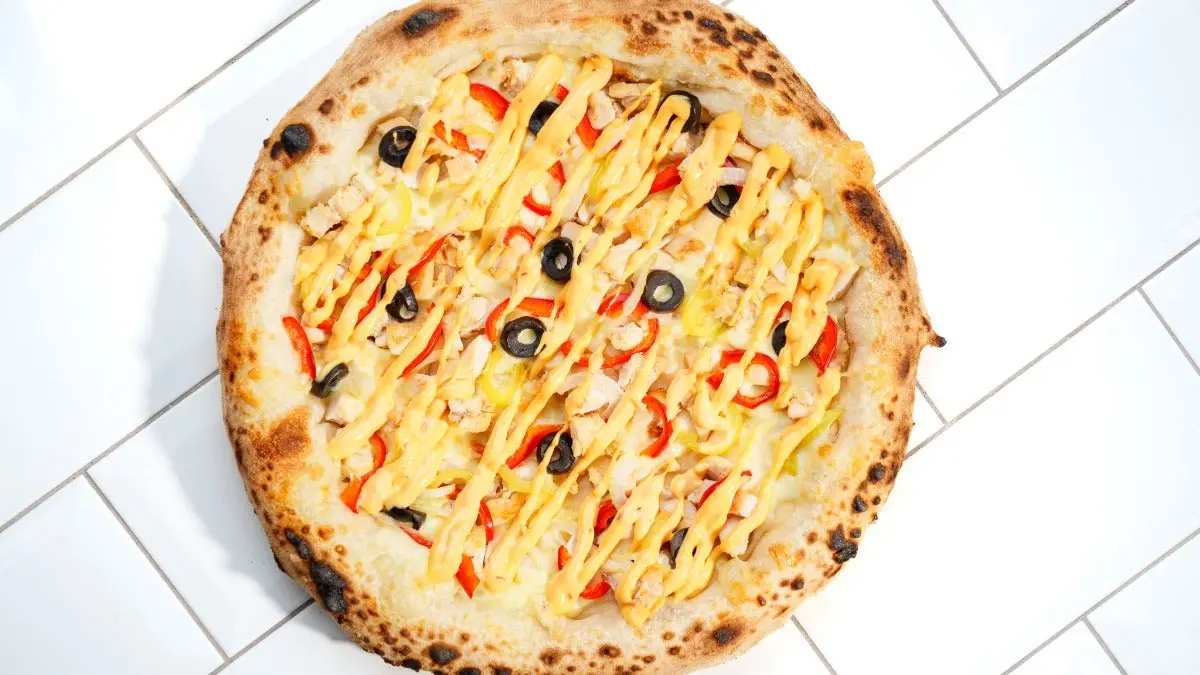Pizza new-yorkaise épicée, sauce tomate relevée et mozzarella dorée au four
