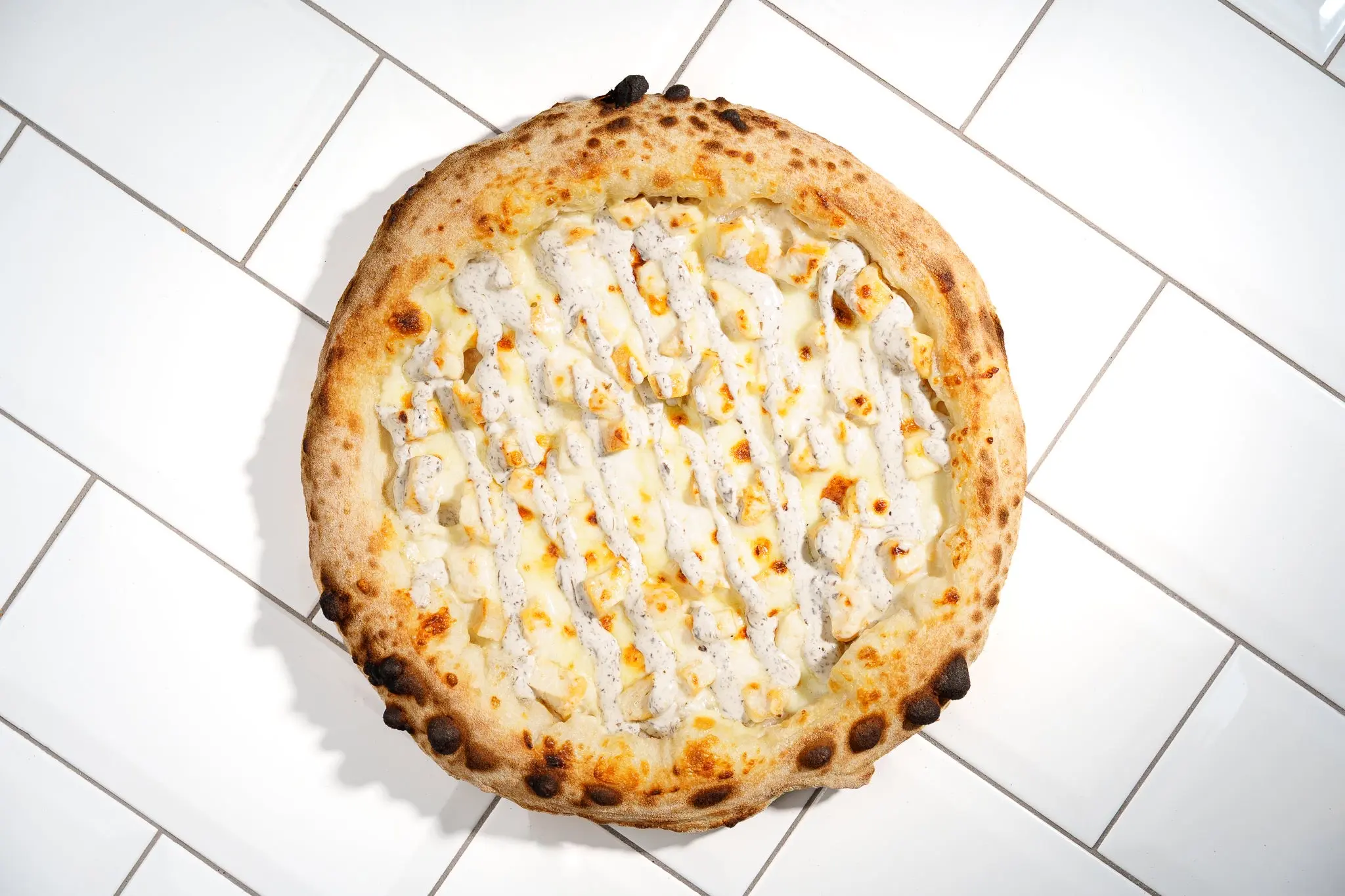 Pizza blanche new-yorkaise, crème à la truffe, poulet et sauce ranch aux herbes